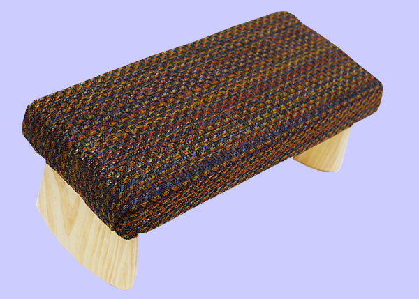 meditation bench with orange, green, brown and blue woven fabric